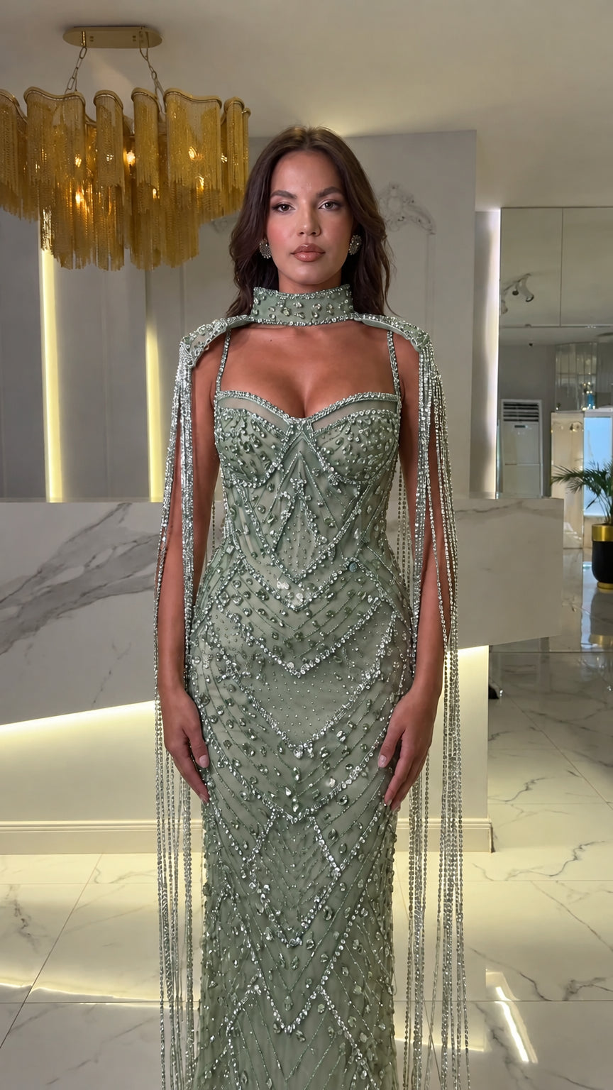 Front view of sage green beaded sweetheart bustier evening gown with tassel fringe cape