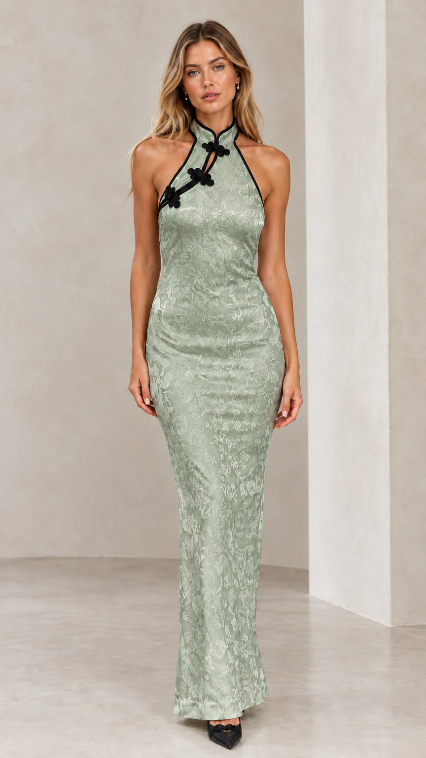 Model wearing sage green floral jacquard halter maxi evening dress
