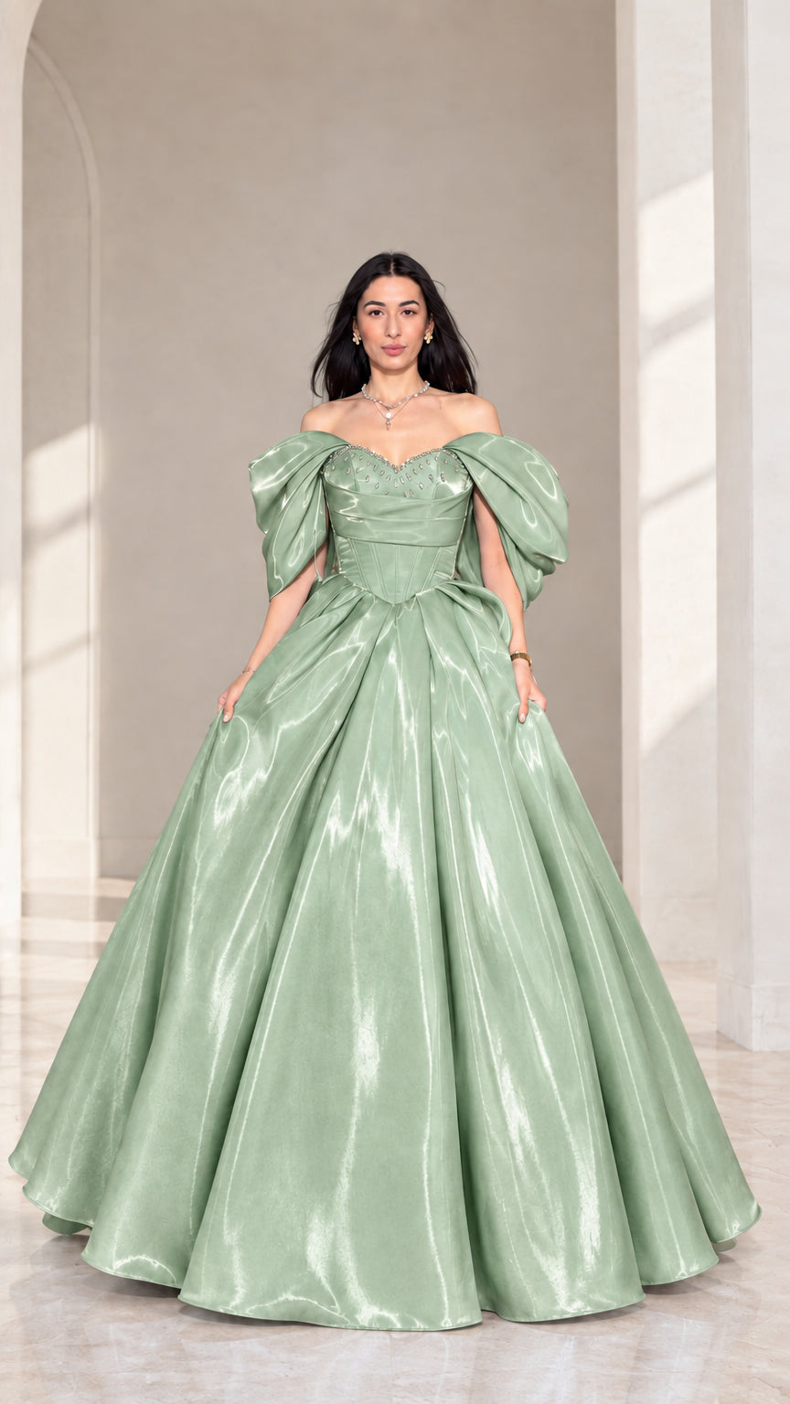 Front view of model wearing sage green off-shoulder beaded corset ball gown