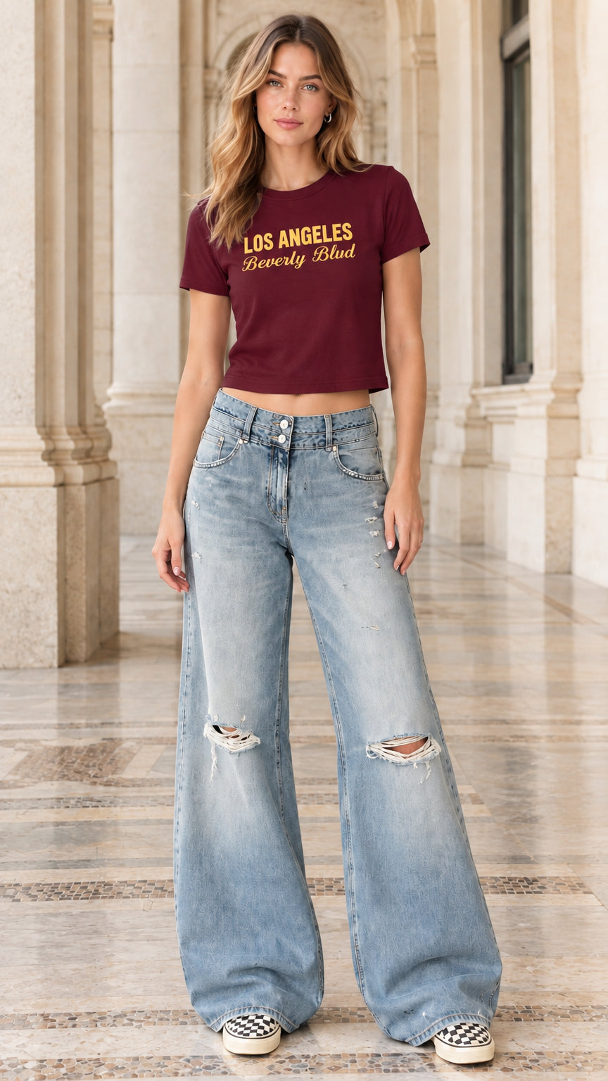 Model wearing burgundy graphic crop t-shirt paired with distressed wide-leg jeans
