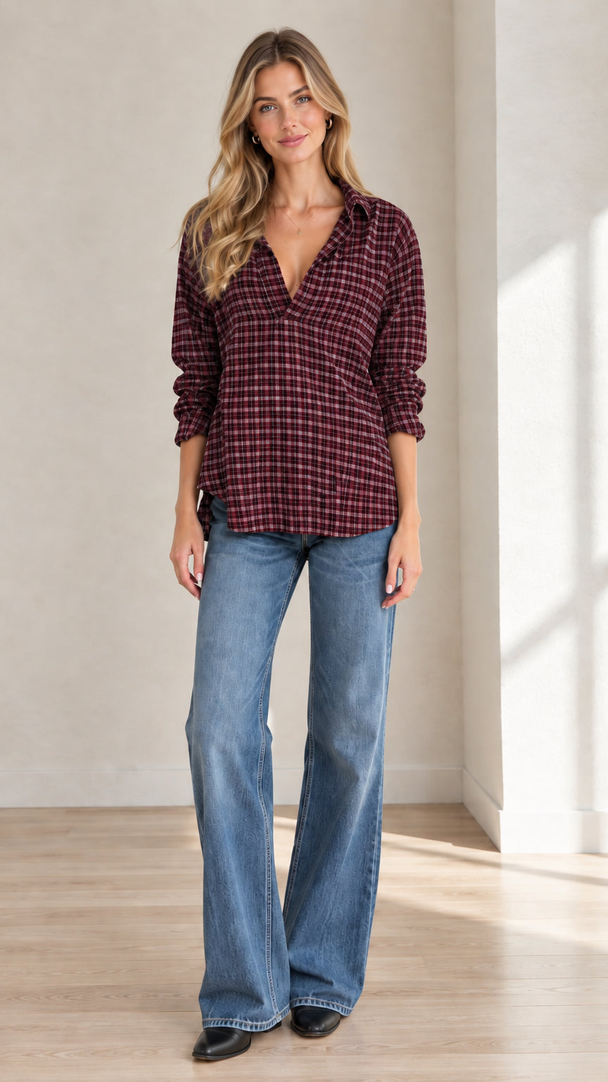 Full front view of model wearing burgundy plaid popover blouse with flare jeans