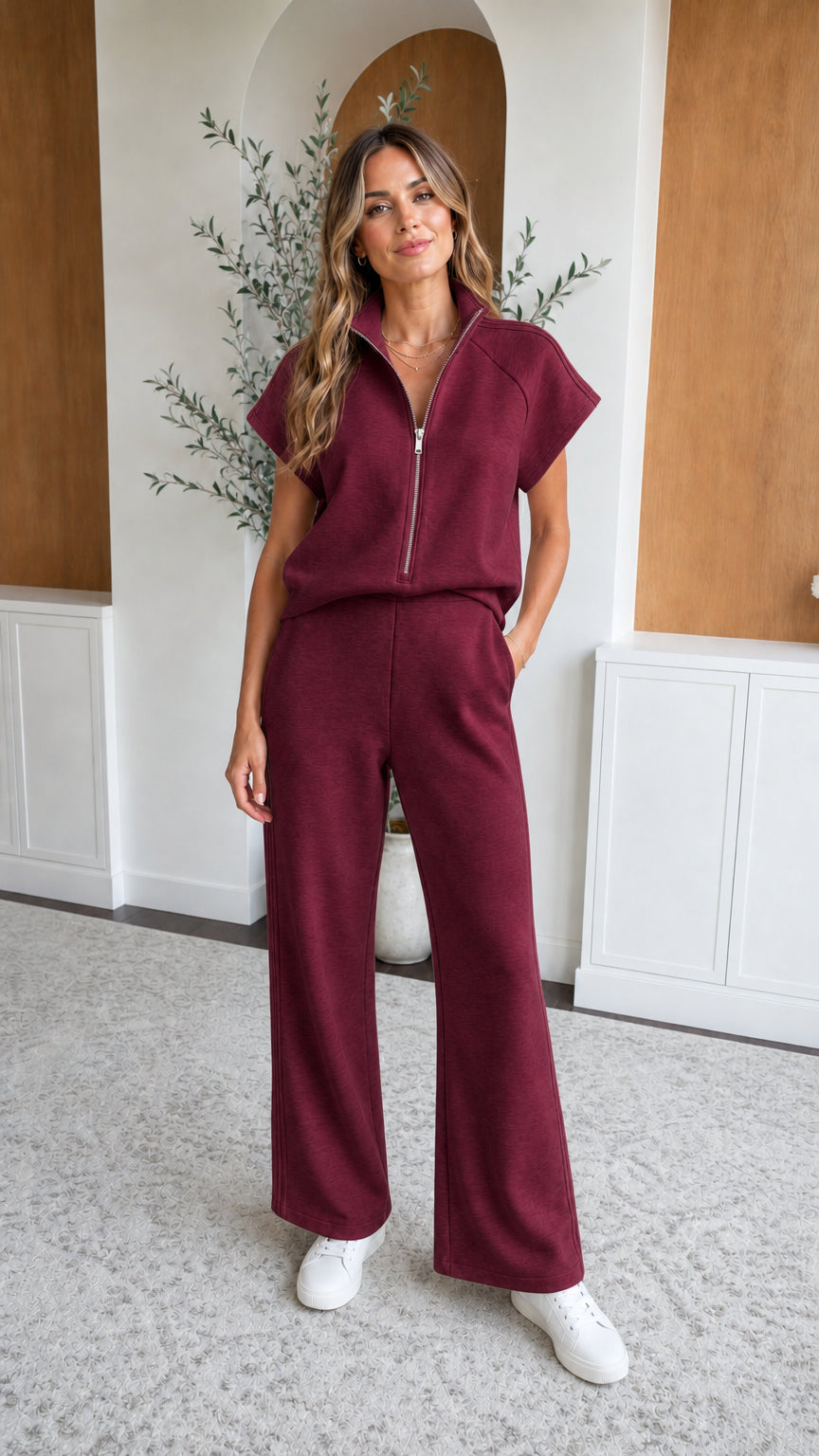 Front full-length view of woman wearing burgundy two-piece zip top and wide leg pants set