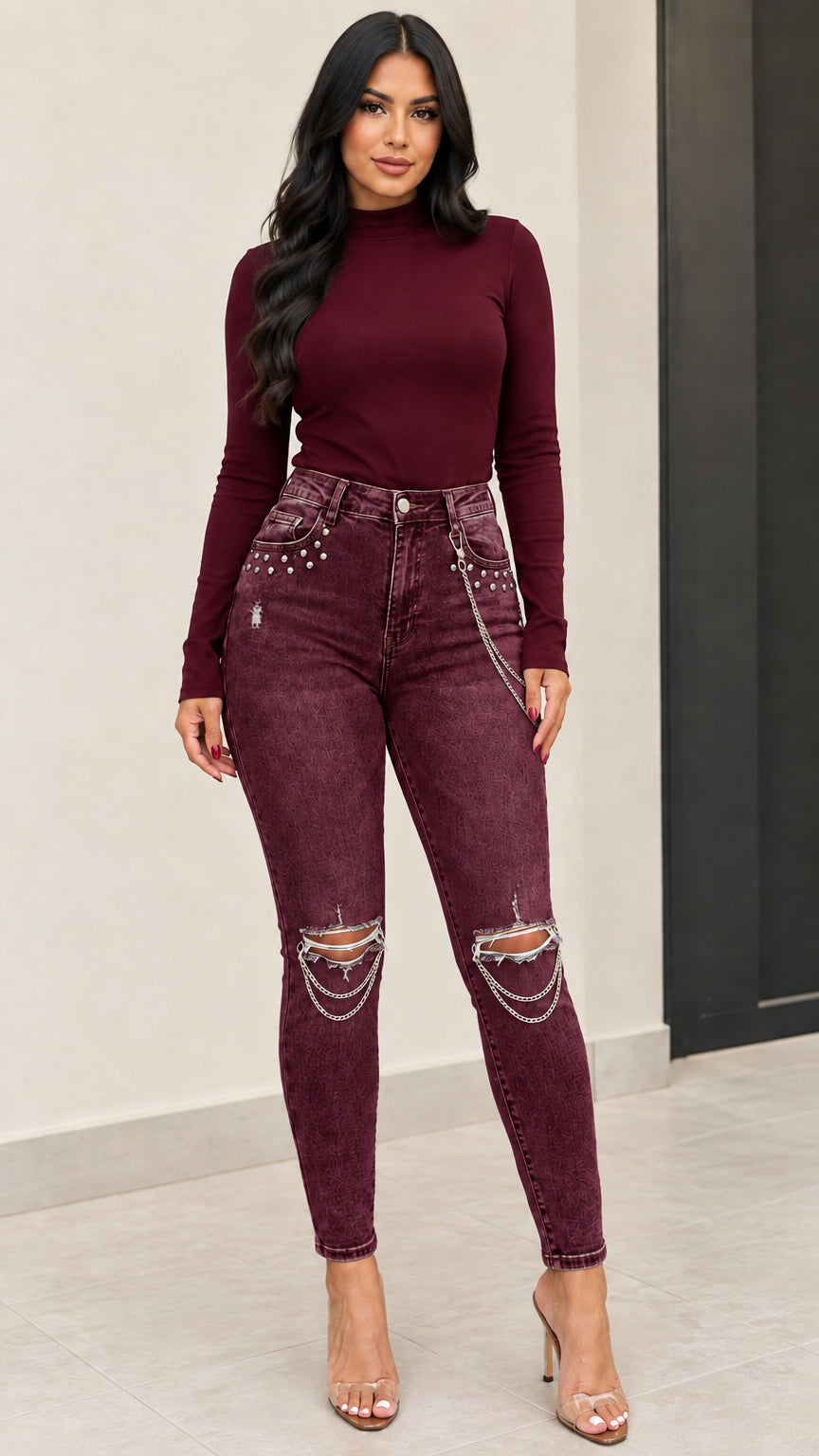 Front full view of woman wearing burgundy acid-wash distressed skinny jeans with knee chains