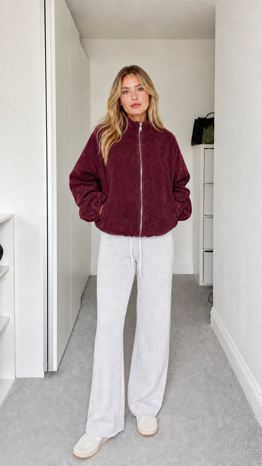 Full-body view of model wearing burgundy fleece zip-up jacket
