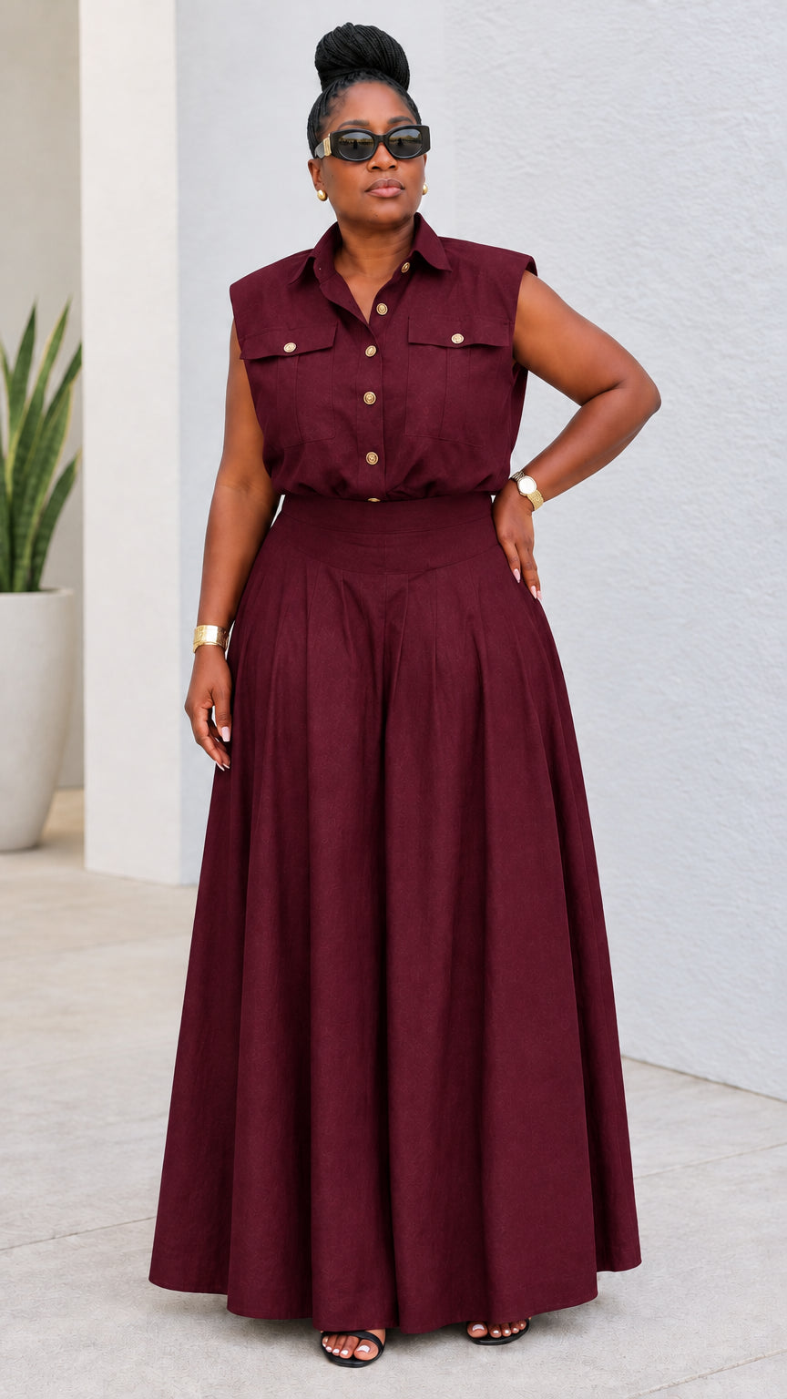 Model wearing burgundy sleeveless button-up shirt and sweeping wide-leg pant set