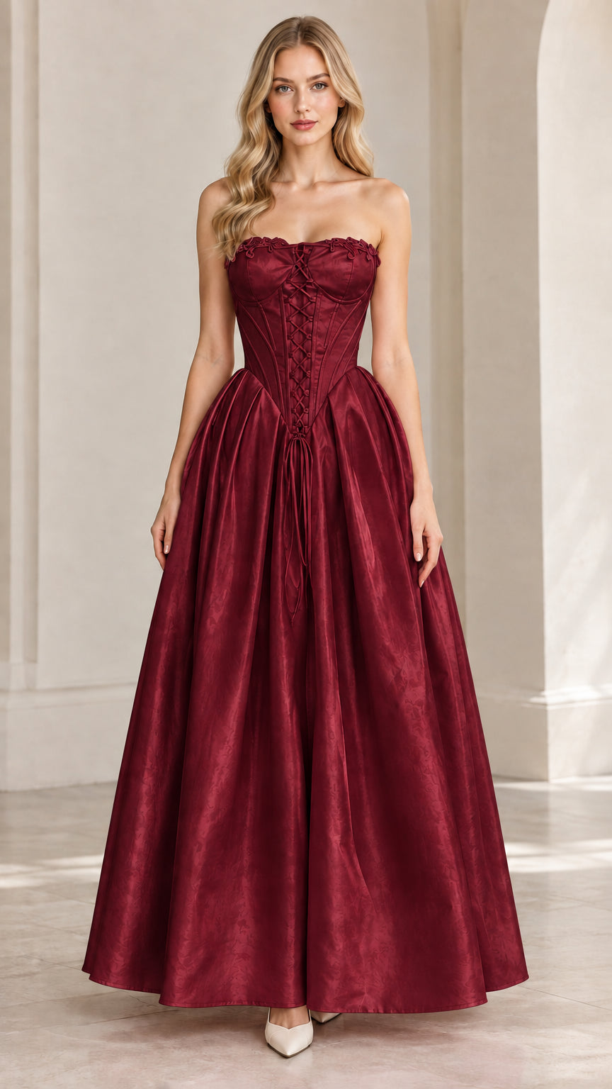Front view of model wearing burgundy strapless corset formal ball gown