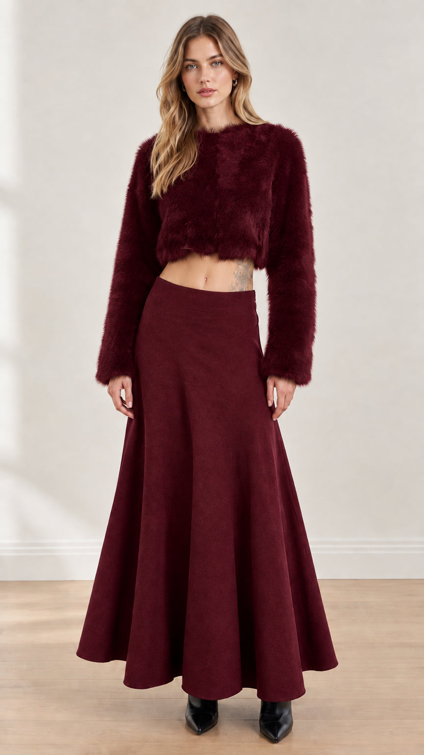 Model wearing rich burgundy fuzzy cropped top and matching flared maxi skirt set