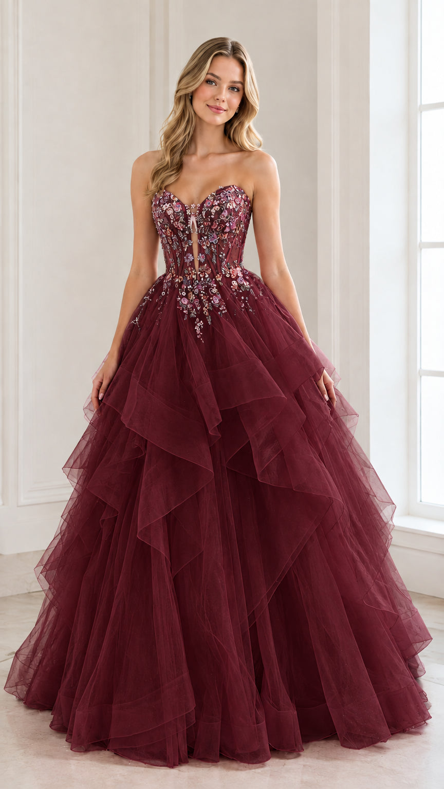 Front view of woman wearing a burgundy red strapless tiered tulle ball gown with beaded bodice