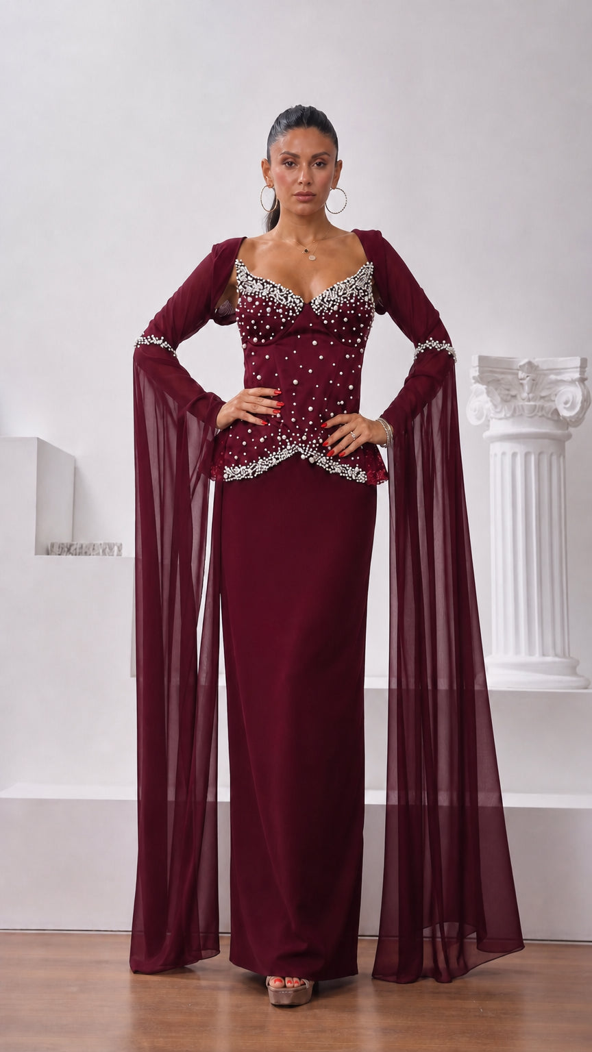 Front view of model wearing burgundy wine red pearl-detailed formal evening dress with cape sleeves