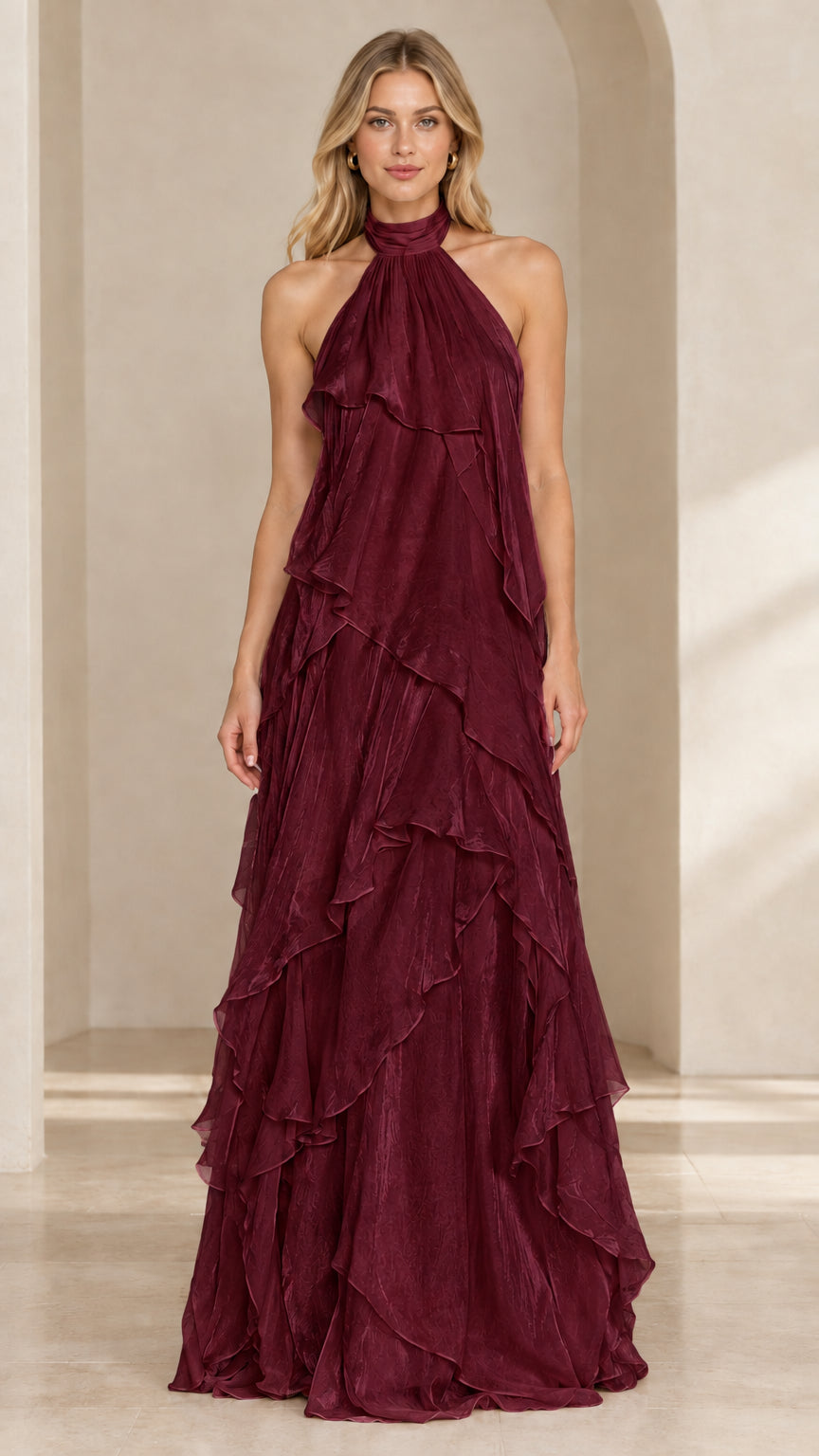 Front view of woman wearing a deep burgundy halter neck tiered ruffle evening dress