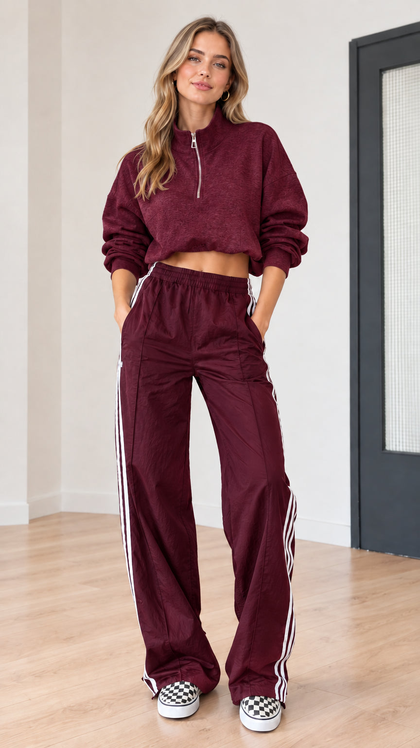 Burgundy two-piece tracksuit set with half-zip cropped top and matching wide-leg track pants