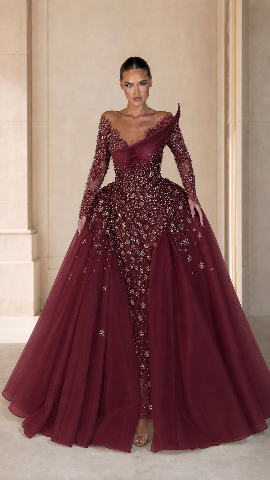 Front view of model wearing rich burgundy crystal embellished evening gown with overskirt