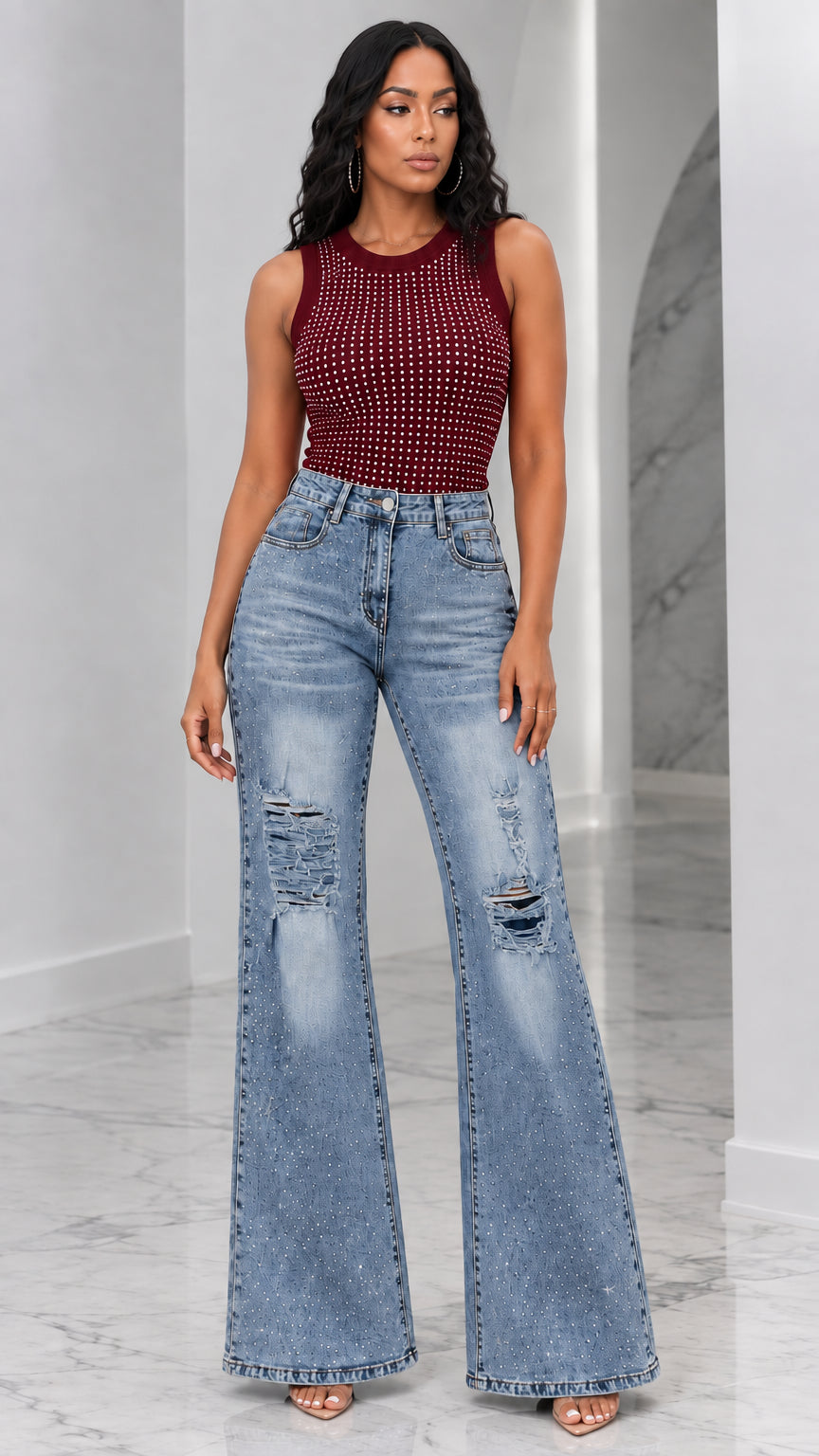 Full-length view of woman wearing burgundy wine rhinestone tank top and distressed flare jeans