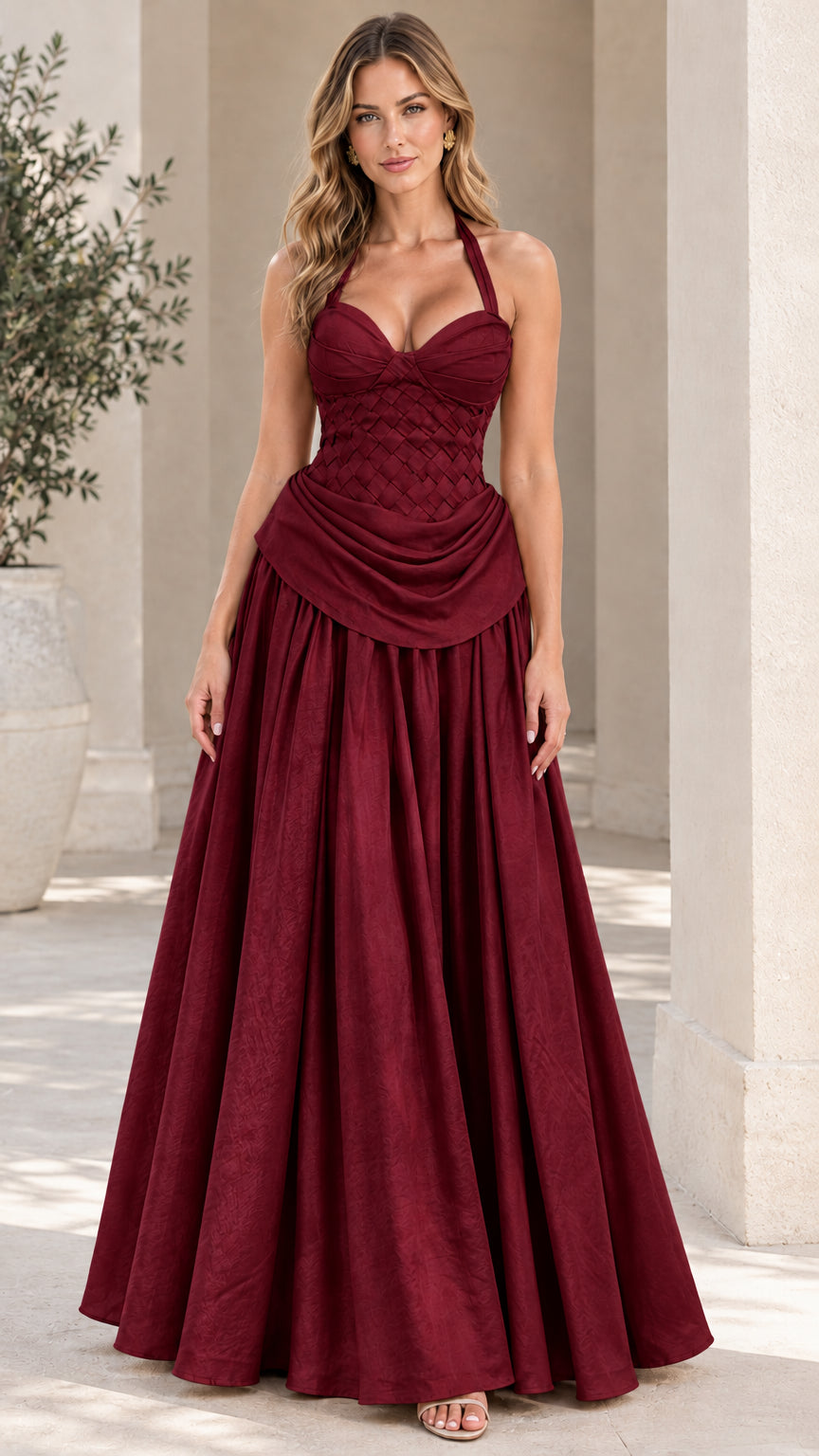 Model wearing the halter neck woven corset evening gown in rich burgundy wine