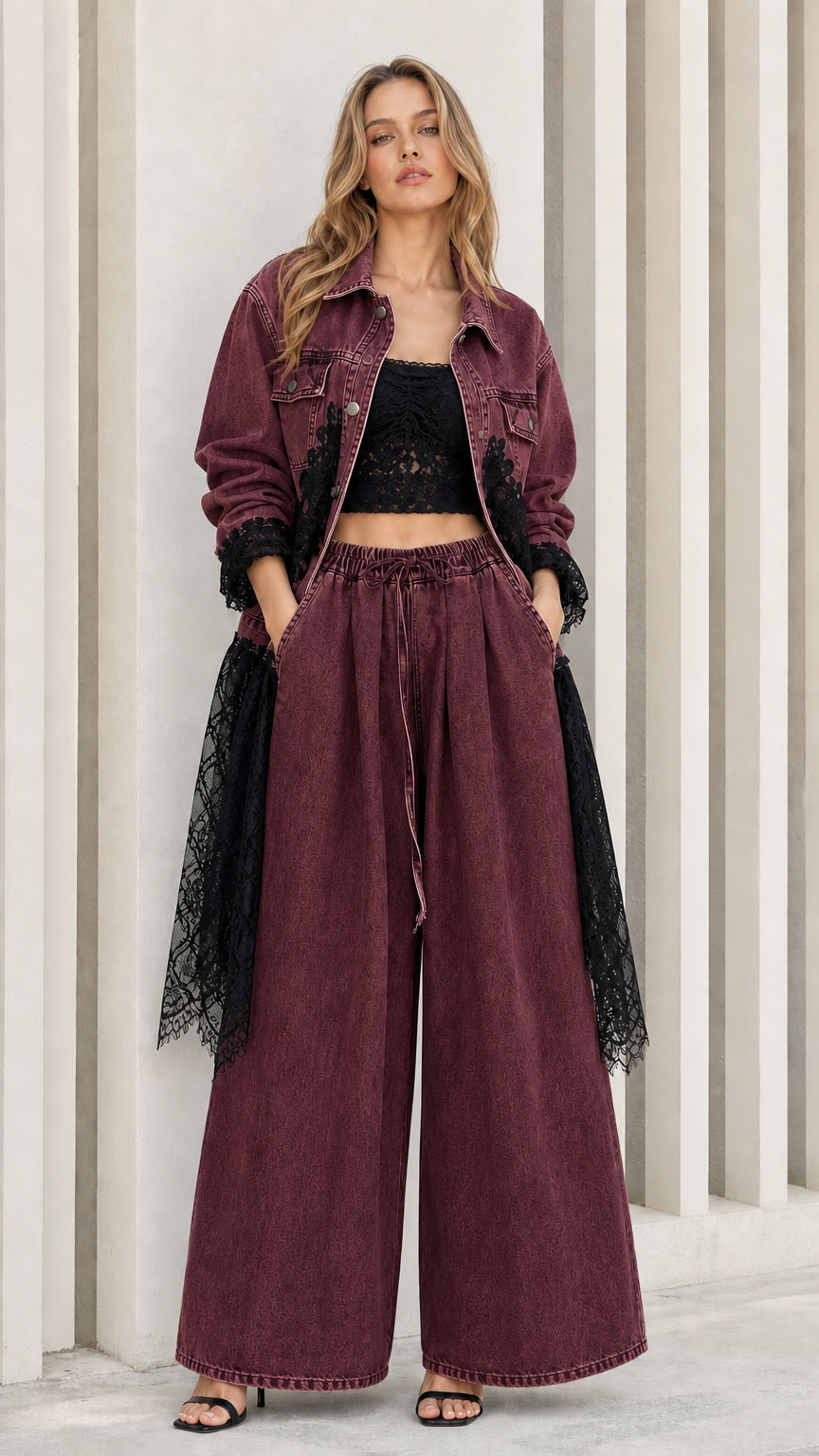 Model wearing burgundy red denim set featuring black lace embroidery and hem