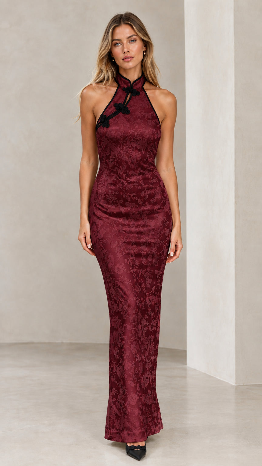 Model wearing burgundy wine red halter jacquard maxi dress with black frog closures