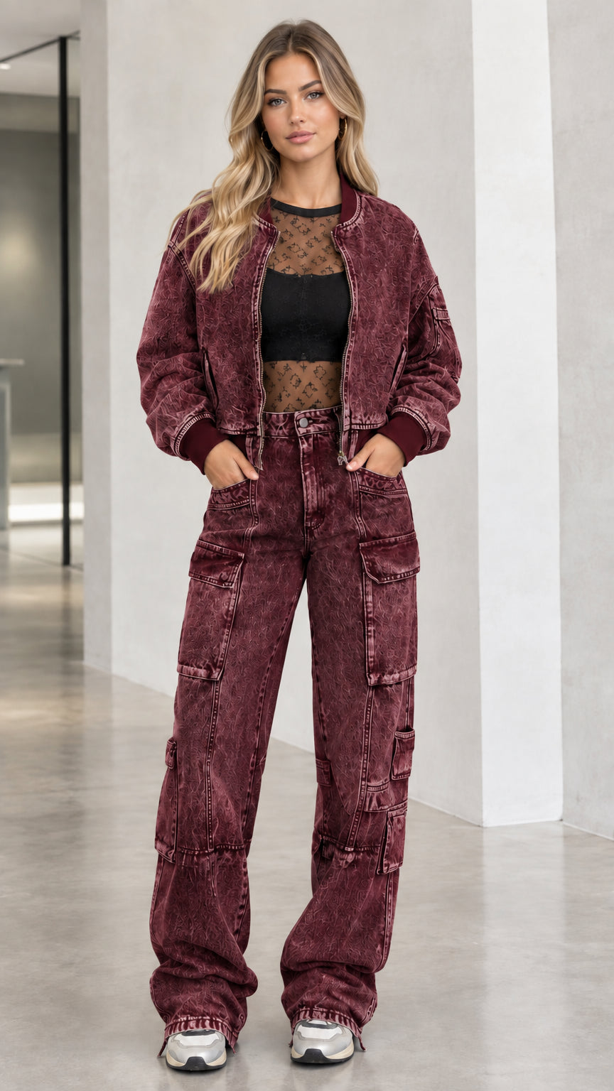 Full body front view of model wearing burgundy washed denim bomber jacket and cargo pants set