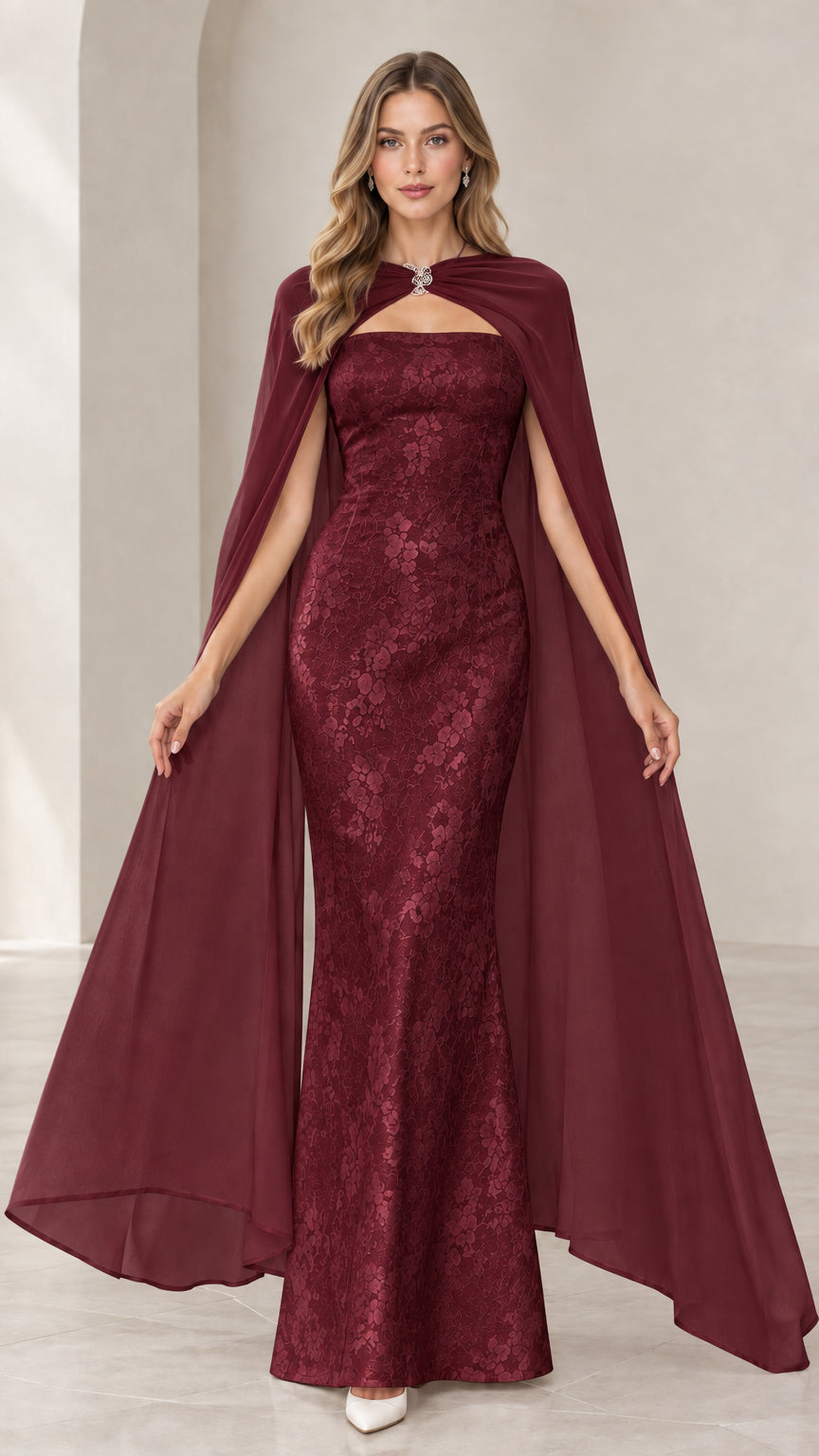 Model wearing burgundy red strapless lace mermaid gown with matching sheer burgundy cape