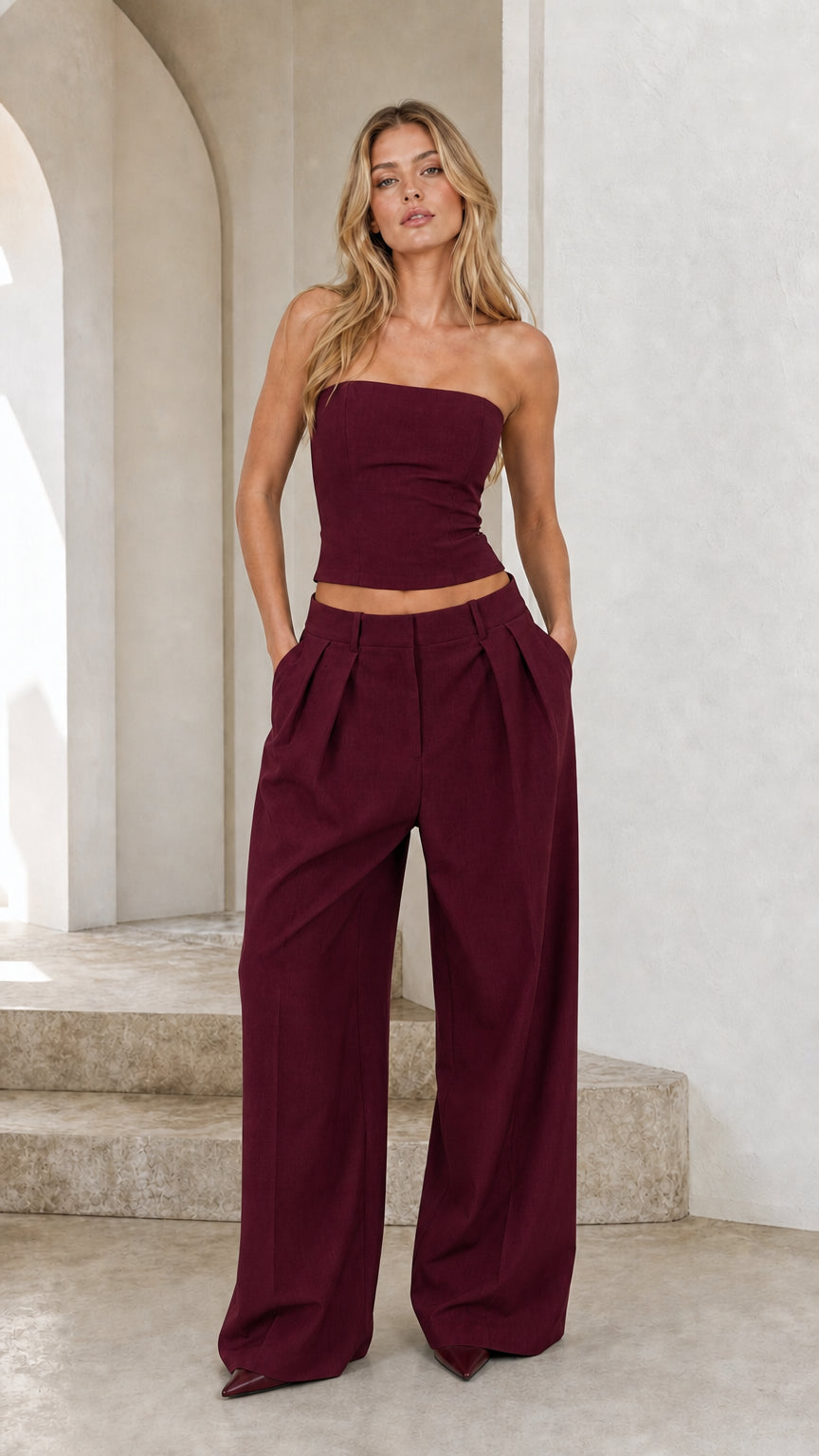 Model wearing burgundy wine strapless crop top and wide-leg pant set