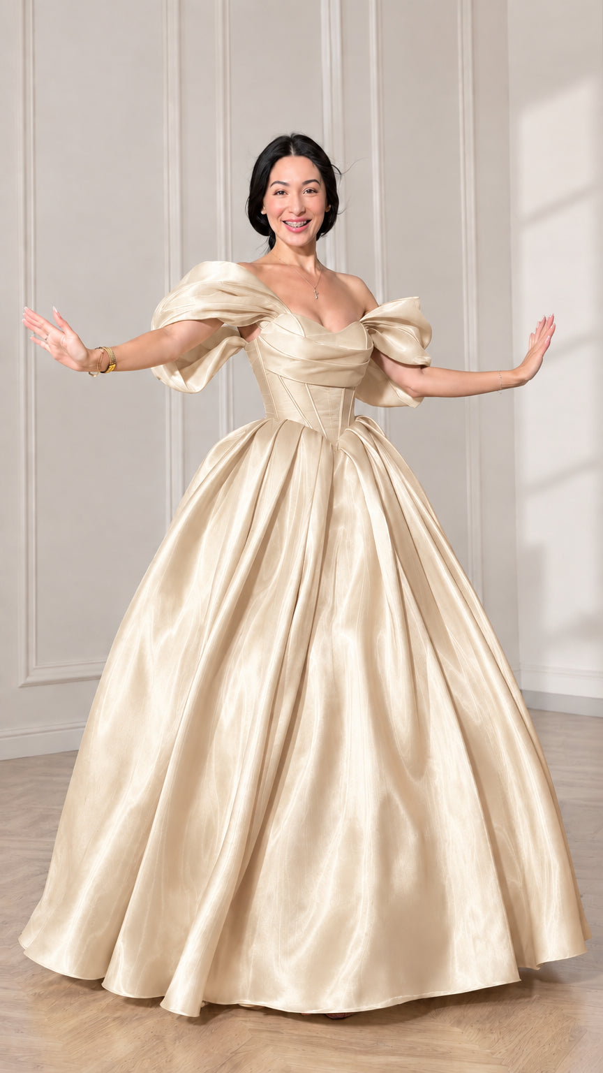 Front view of model wearing a champagne gold off-shoulder puff sleeve corset ball gown