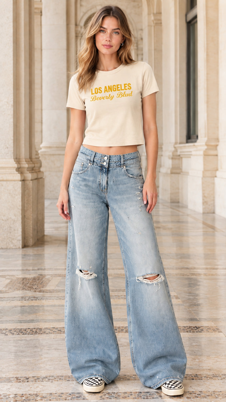 Model wearing cream graphic crop top paired with light-wash wide-leg ripped jeans