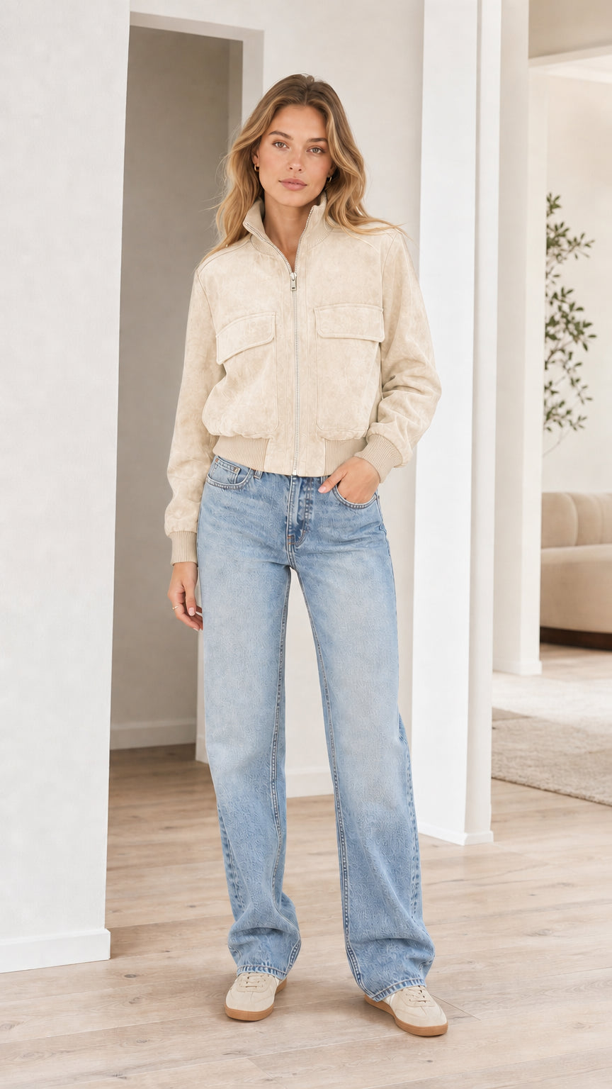 Model wearing cream beige faux suede zip-up bomber jacket with light wash jeans