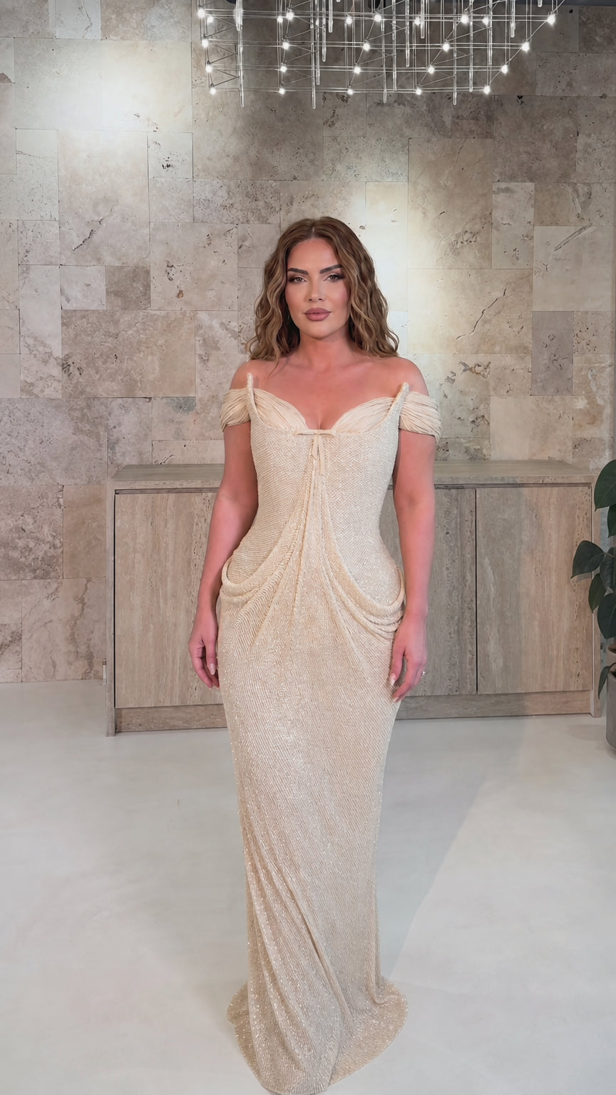 Model wearing champagne gold glitter draped formal evening dress