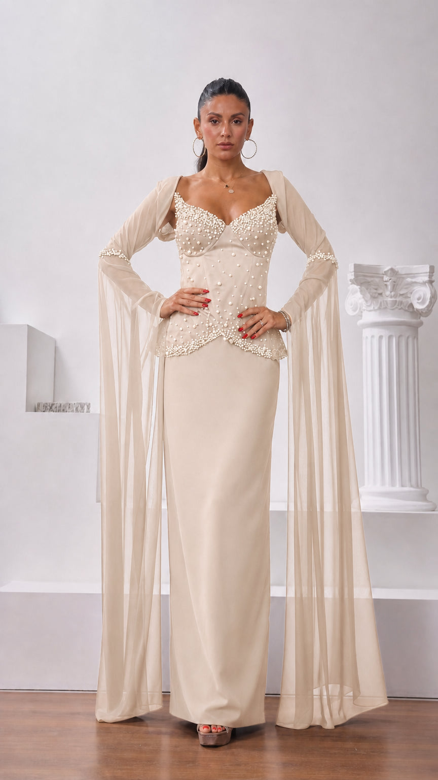 Front view of model wearing champagne cream pearl-embellished corset maxi dress with flowing sleeves