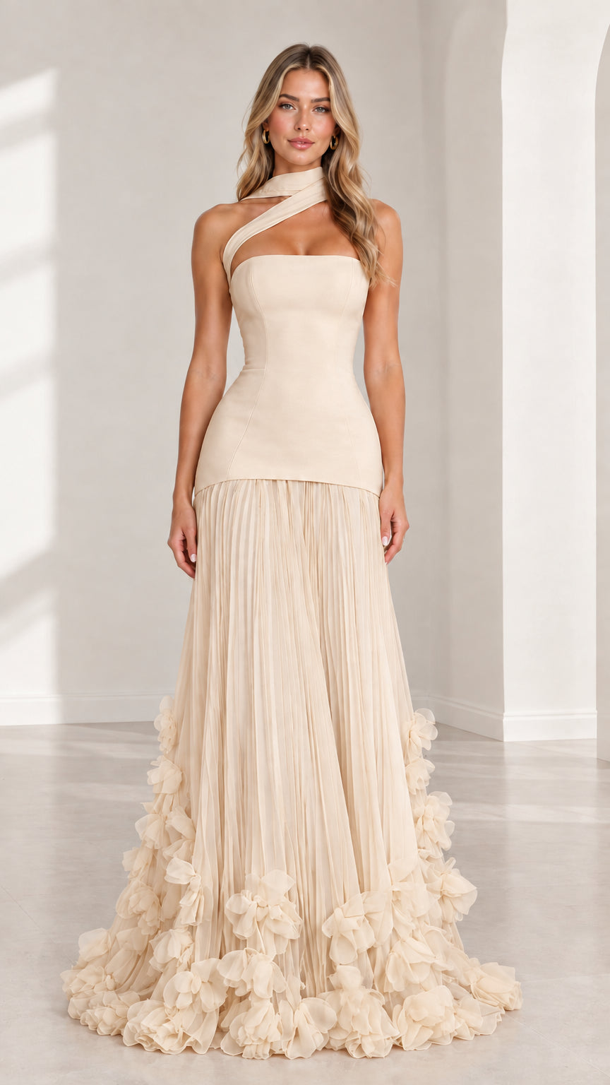 Front full-length view of model wearing champagne beige asymmetric drop waist evening gown