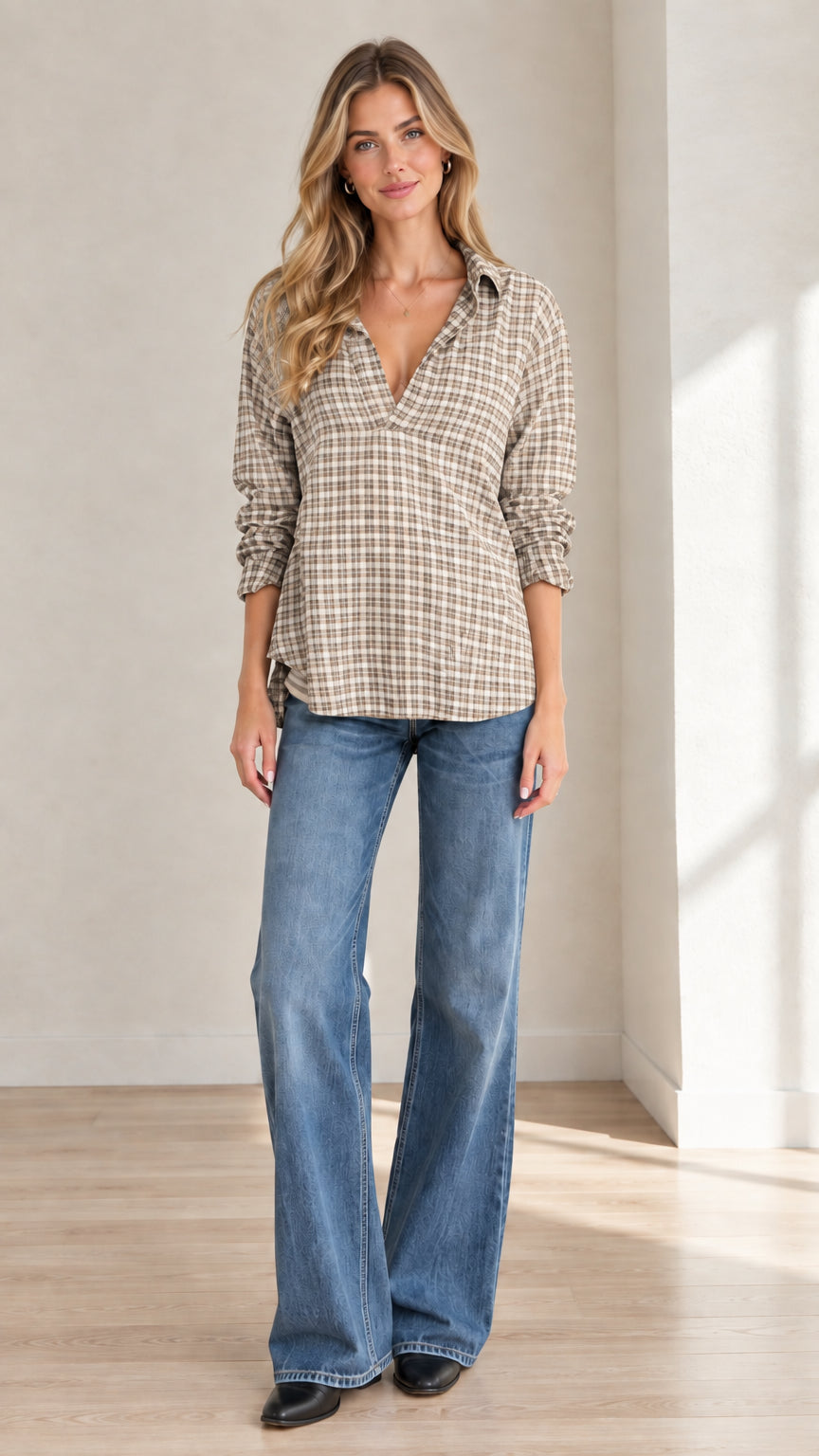 Full front view of model wearing beige plaid popover blouse with flare jeans