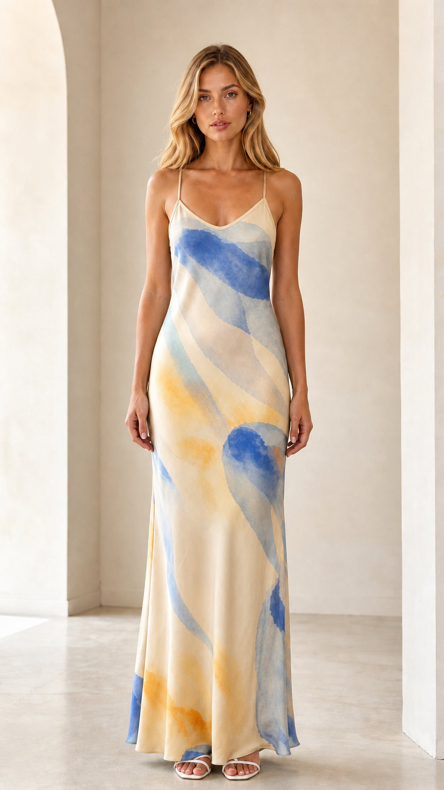 Model wearing champagne yellow and blue abstract print satin maxi dress