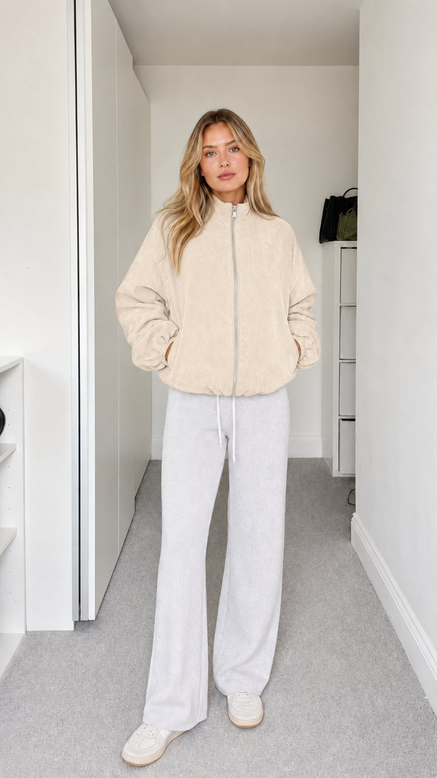 Full-body view of model wearing cream fleece zip-up jacket