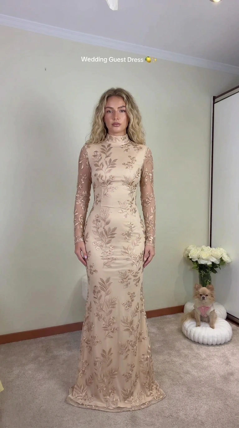 Front view of woman wearing champagne embroidered long sleeve evening gown