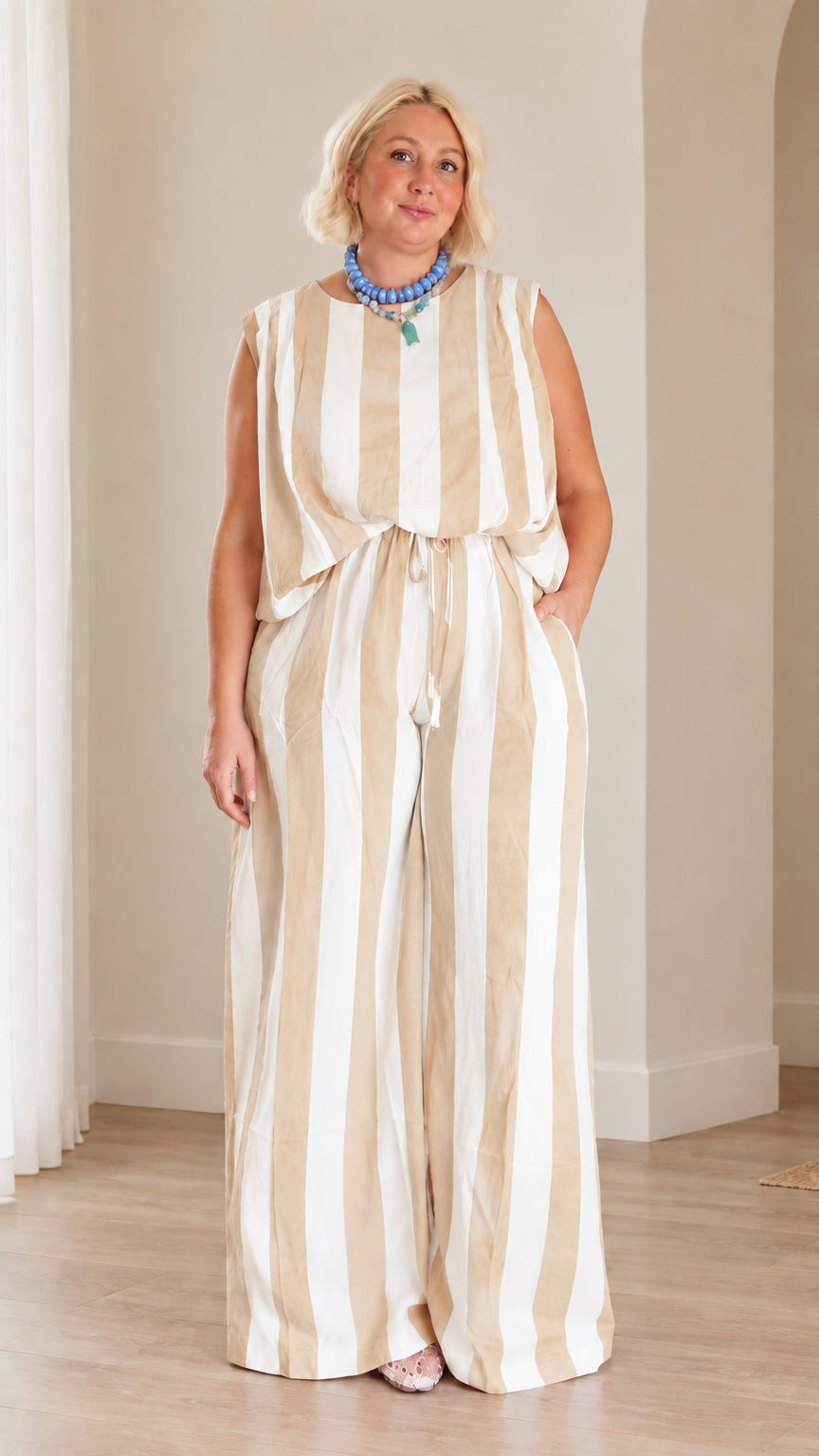 Full front view of woman wearing beige and white striped sleeveless top and wide leg trousers set